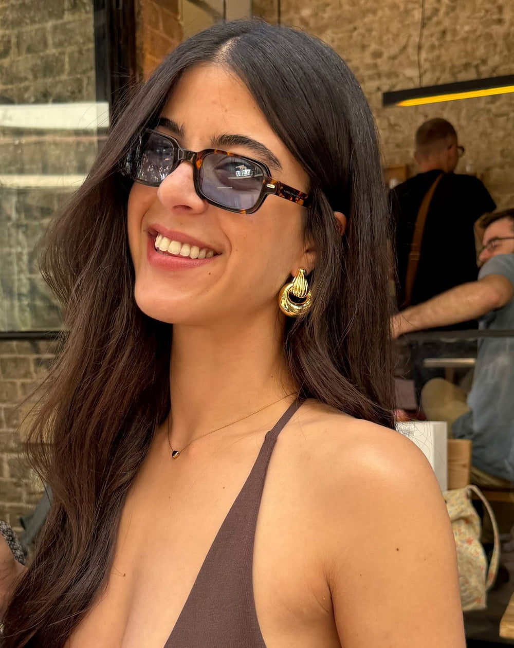 Smiling woman wearing gold CHARM earring